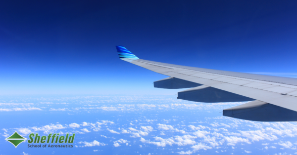 The wing of an airplane is seen over a beautiful blue sky as it flies above the clouds on a clear day. This indicates that the article will discuss flying, more specifically, it tells about the day in the life of a flight dispatcher.