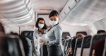 airline attendant wearing mask on crowded flight