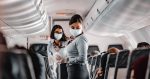Permalink to Airlines Packing Flights During COVID-19 Pandemic airline attendant wearing mask on crowded flight